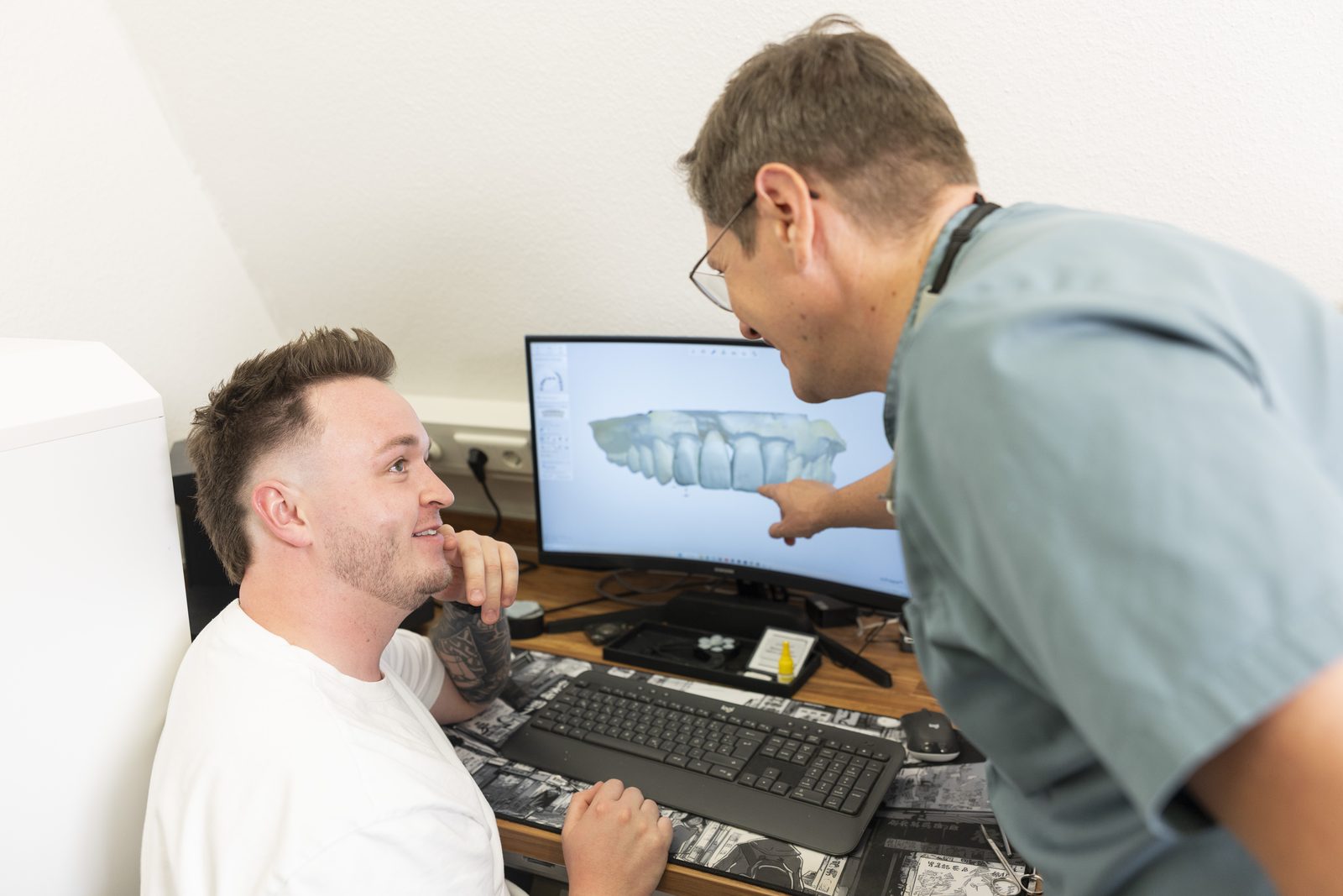 Dr. Alius erklärt einem Patienten am Bildschirm die digitale Planung der implantatgetragenen Versorgung – Zahnarzt in Nürnberg